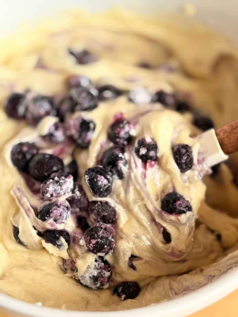 Folding blueberries into bakery-style blueberry muffin batter
