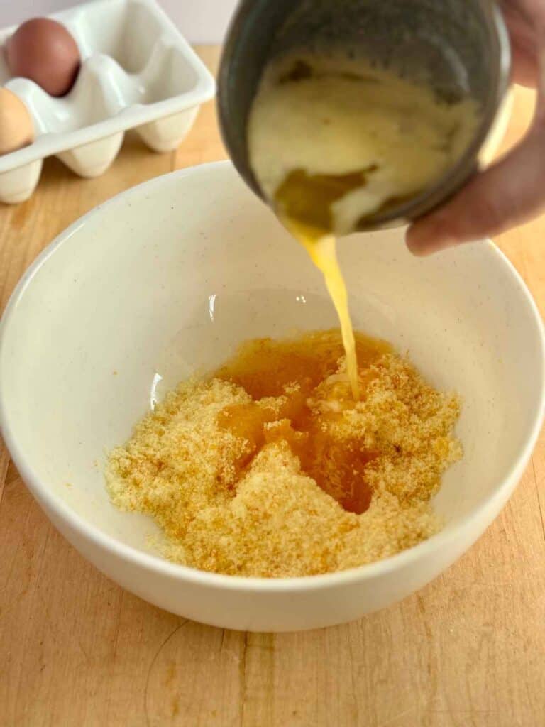 melted butter pouring into sugar and orange zest 