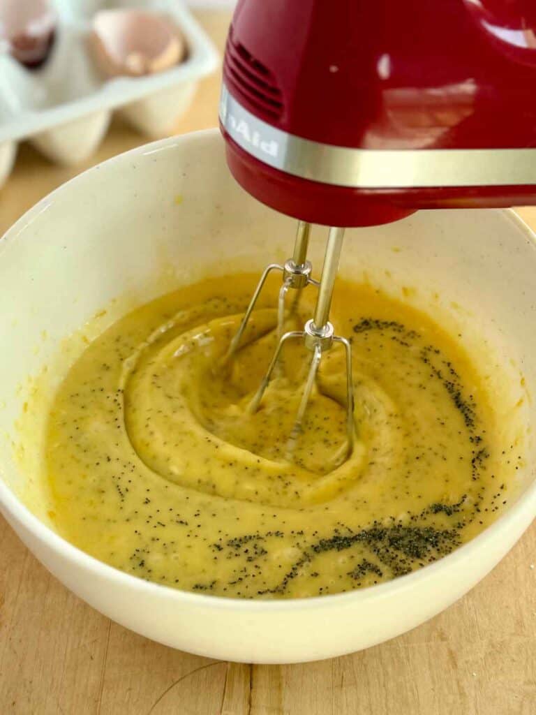mixing wet ingredients and poppy seeds in to butter and sugar mixture 