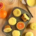 orange poppy seed muffins arranged in muffin tin with orange