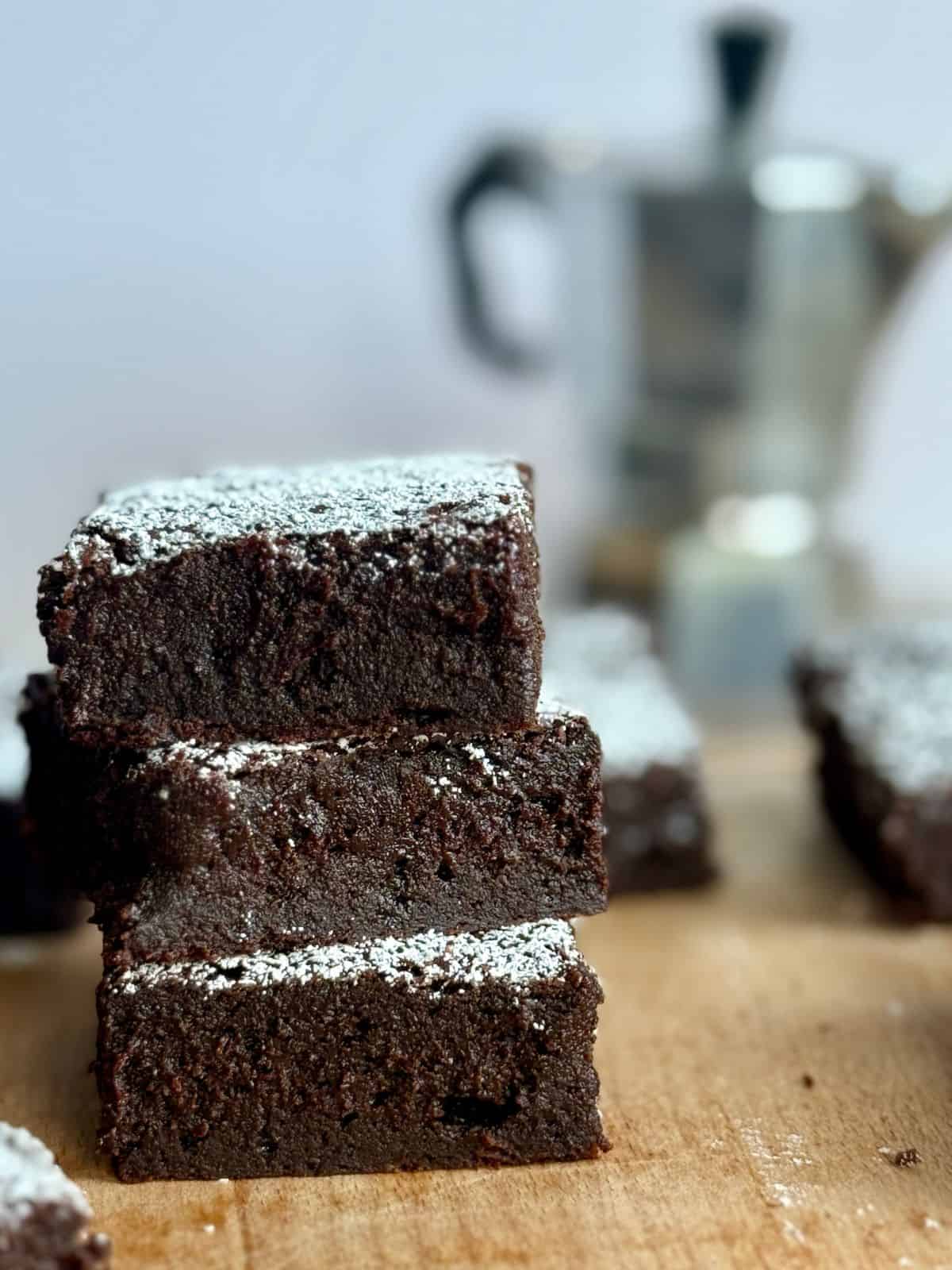 espresso brownies-stack of brownies on wooden board with espresso pot in background
