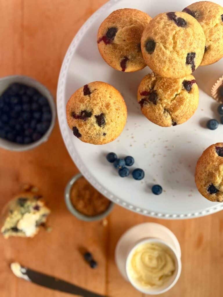 bakery-style-blueberry-muffins-on-white-cake-stand-overhead-shot