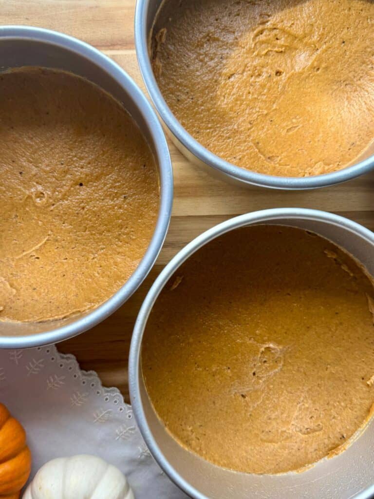 brown butter pumpkin cake-cake batter spread into three round cake pans