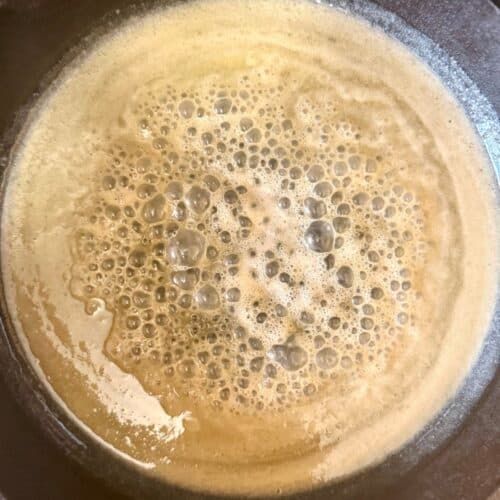 cast iron skillet cinnamon roll caramel bubbling in pan