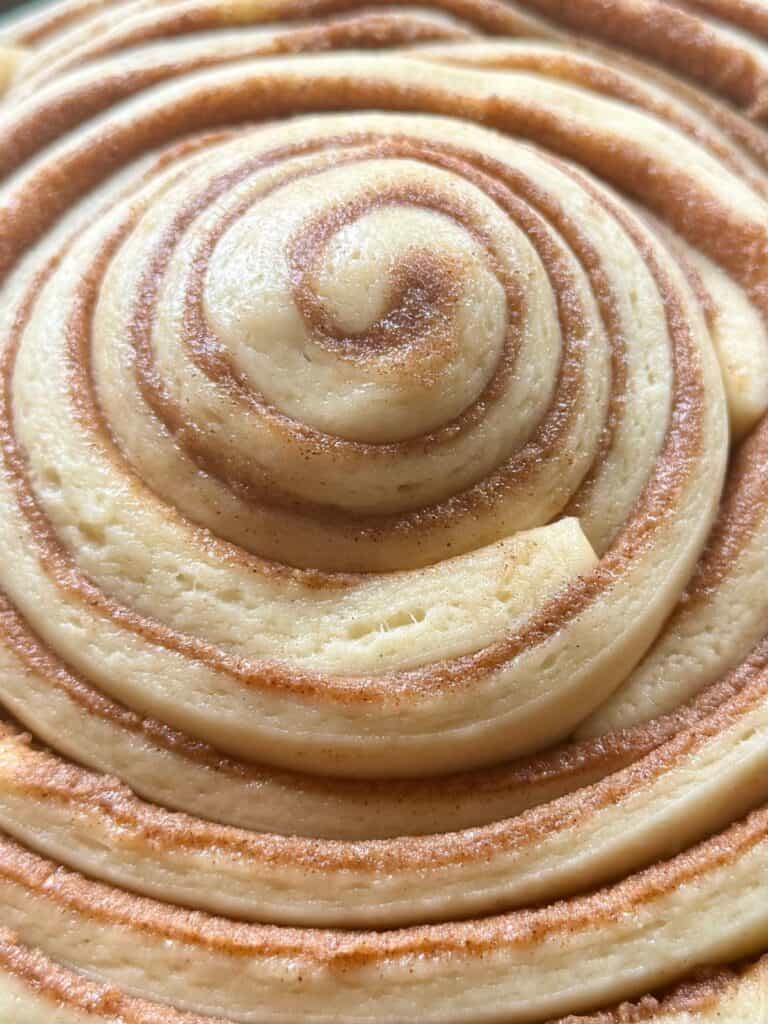 cast iron skillet cinnamon roll close up of fully proofed dough before baking