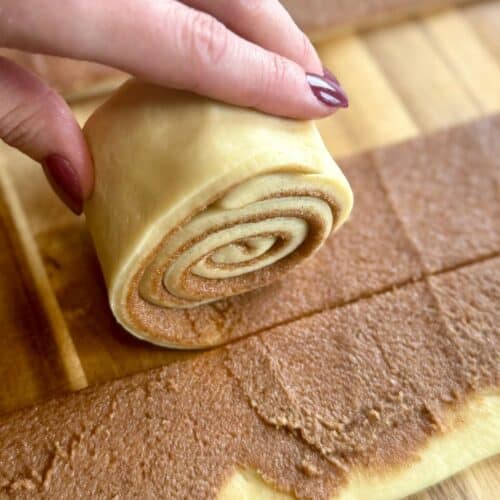 cast iron skillet cinnamon roll rolling strips into roll