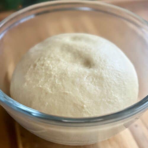 cast iron skillet cinnamon roll smooth dough in glass bowl before proofing