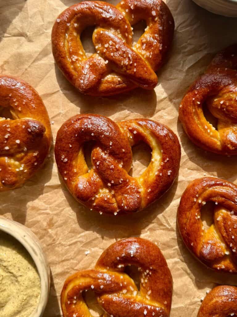 mini soft pretzels arranged on parchment paper with dips in the corner