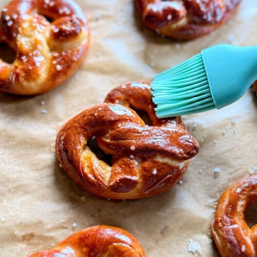mini soft pretzels-brushing butter onto pretzel out of oven