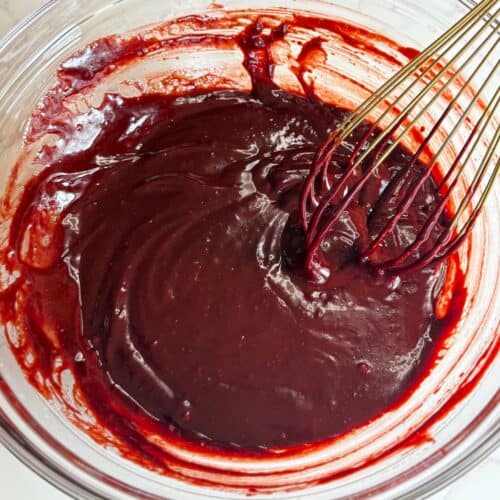 flourless red velvet torte-chocolate and egg yolk mixture in glass bowl with whisk