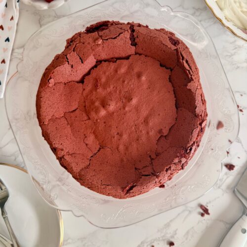flourless red velvet torte on serving plater sunken crackly top after cooling