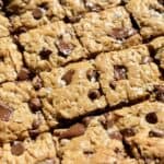 golden oatmeal chocolate chip cookie bars sliced with melty chocolate and flaky salt