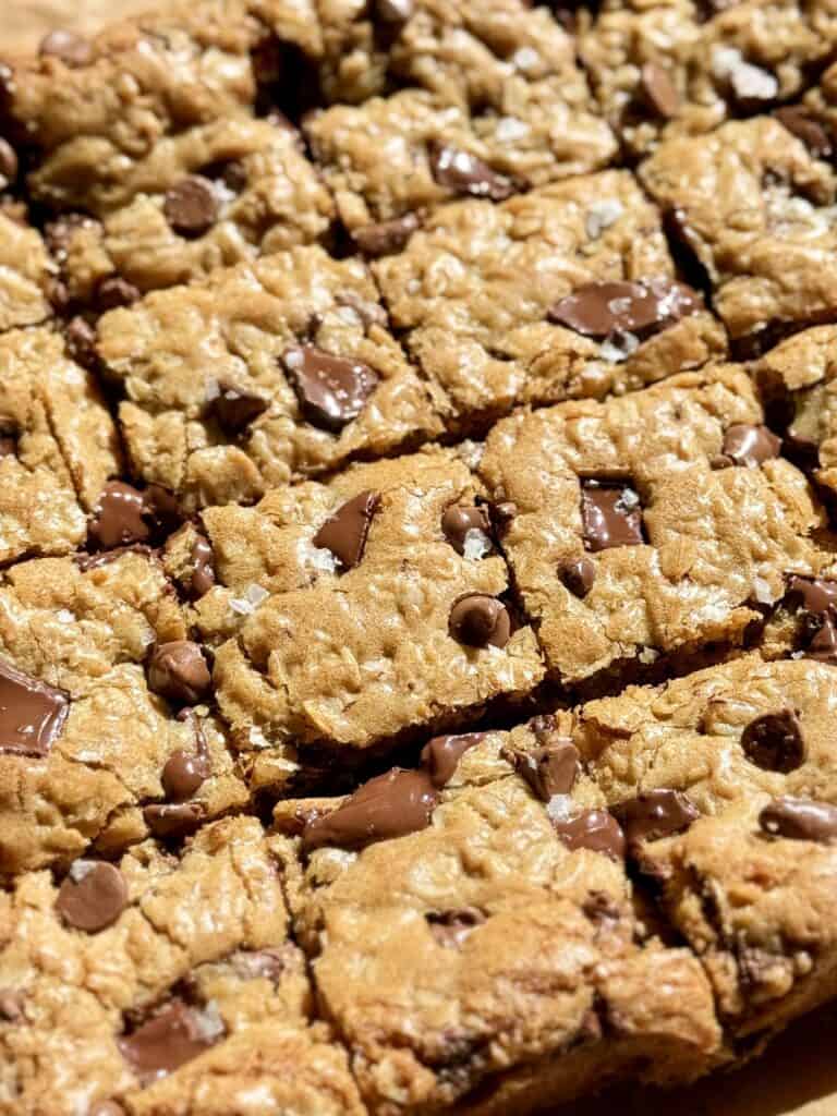 golden oatmeal chocolate chip cookie bars sliced with melty chocolate and flaky salt