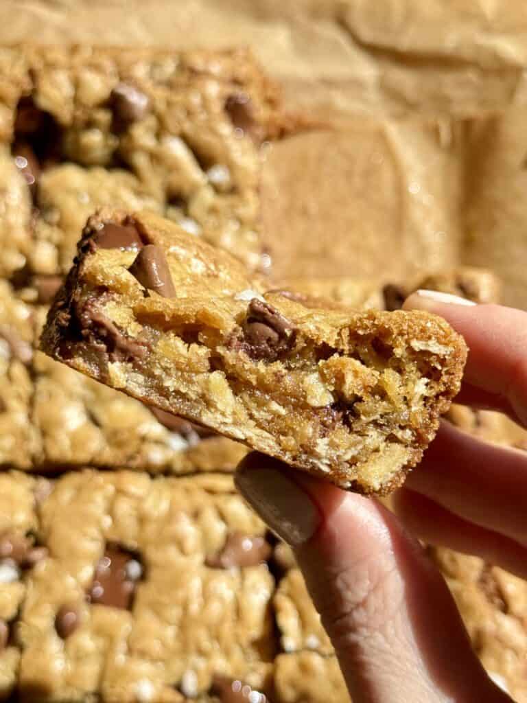 holding oatmeal chocolate chip cookie bar showing texture of oats and chocolate inside the bar 
