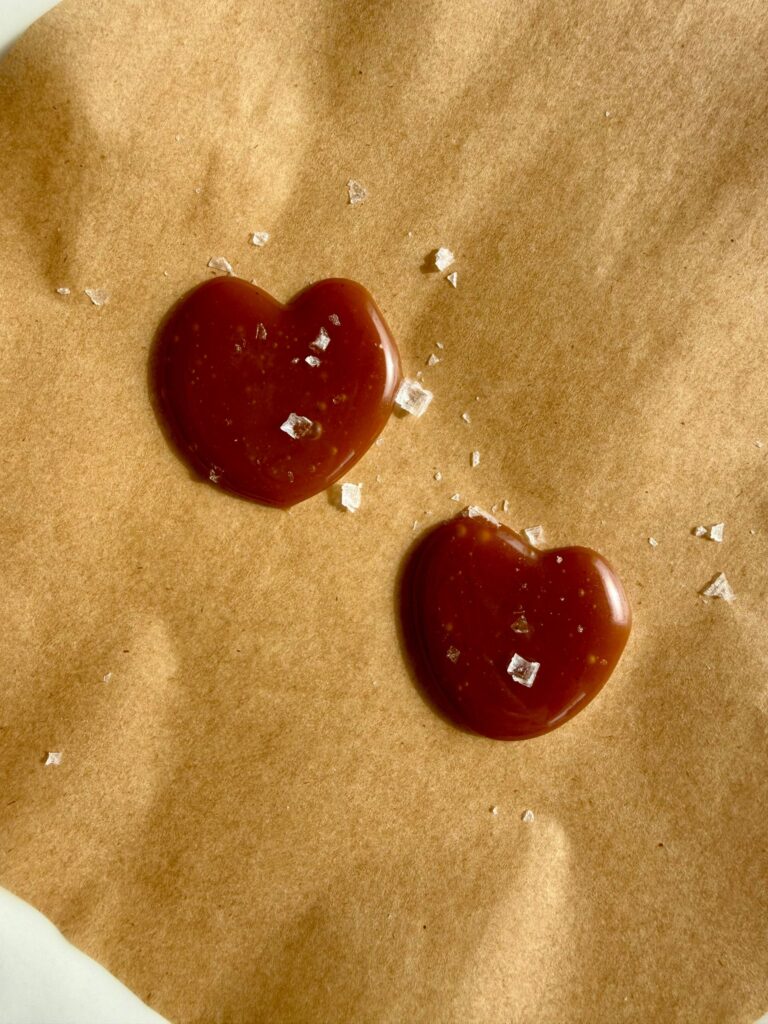 salted caramel molten lava cakes - caramel for centers on plate in shapes of hearts with sprinkle of flaky salt
