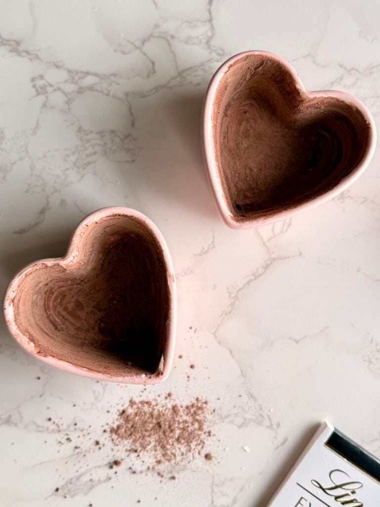 salted caramel molten lava cakes two pink heart ramekins coated in butter and cocoa powder