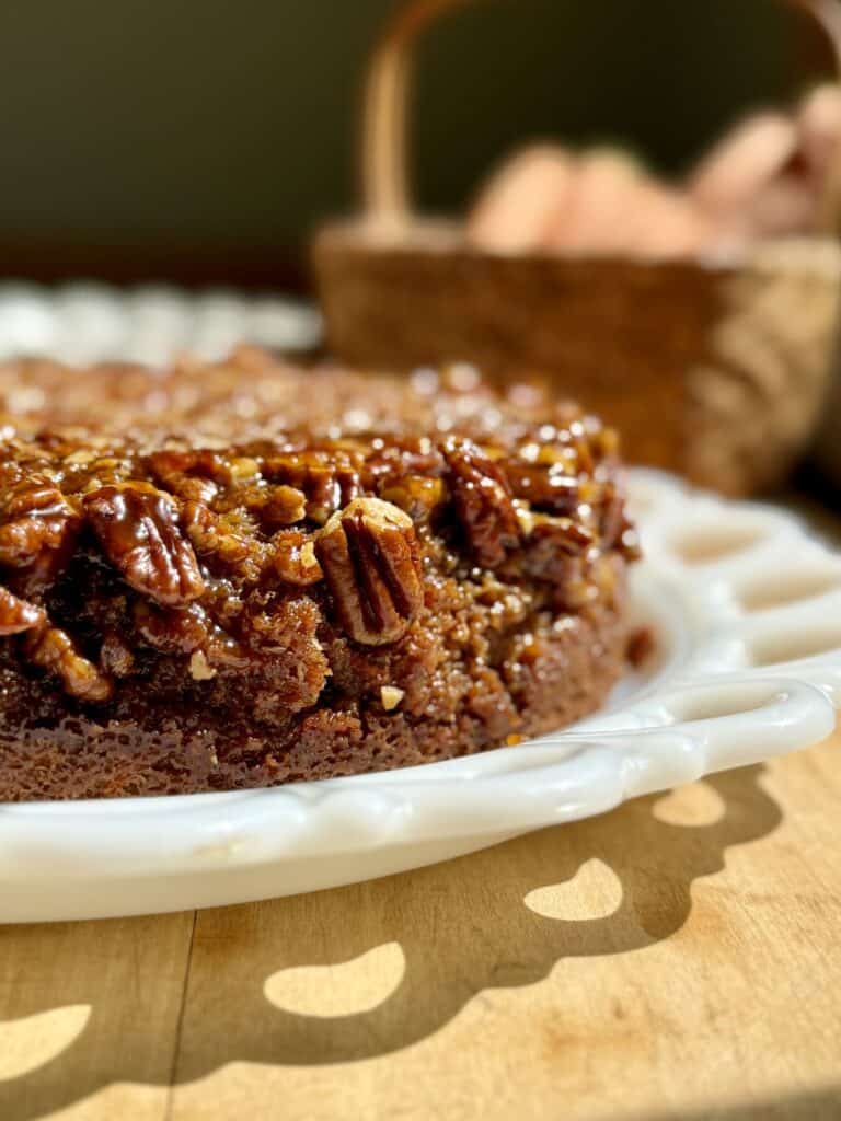 close up of golden sticky caramel pecans on  top and side of carrot cake 