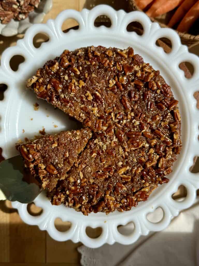 sticky pecan carrot cake with slice cut and serving spatula pick up 