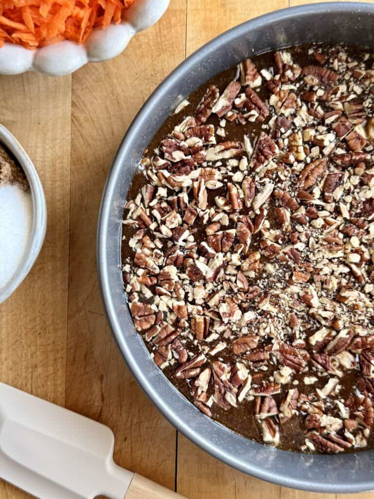 sticky pecan layer poured into cake pan sprinkled with the toasted pecans