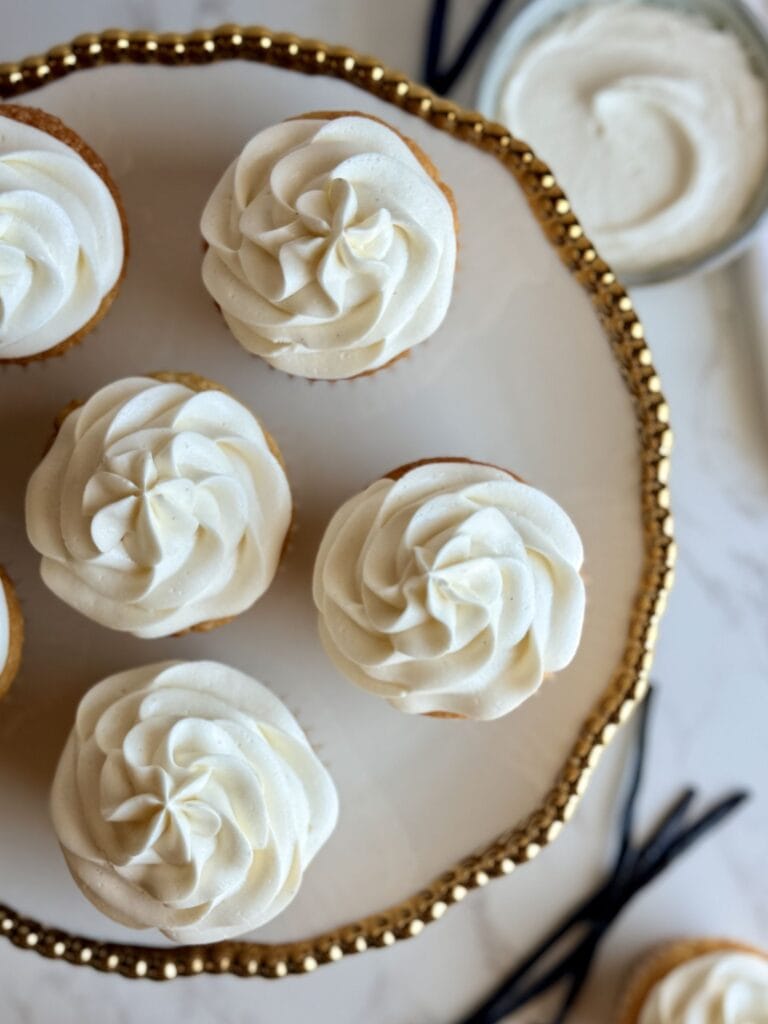 classic vanilla cupcakes on cake stand showing the swirls of buttercream on top