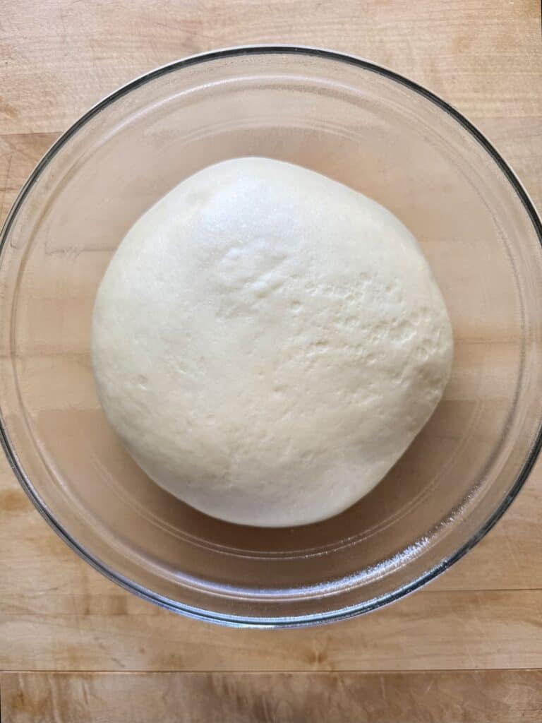 dinner rolls dough in bowl for first rise 