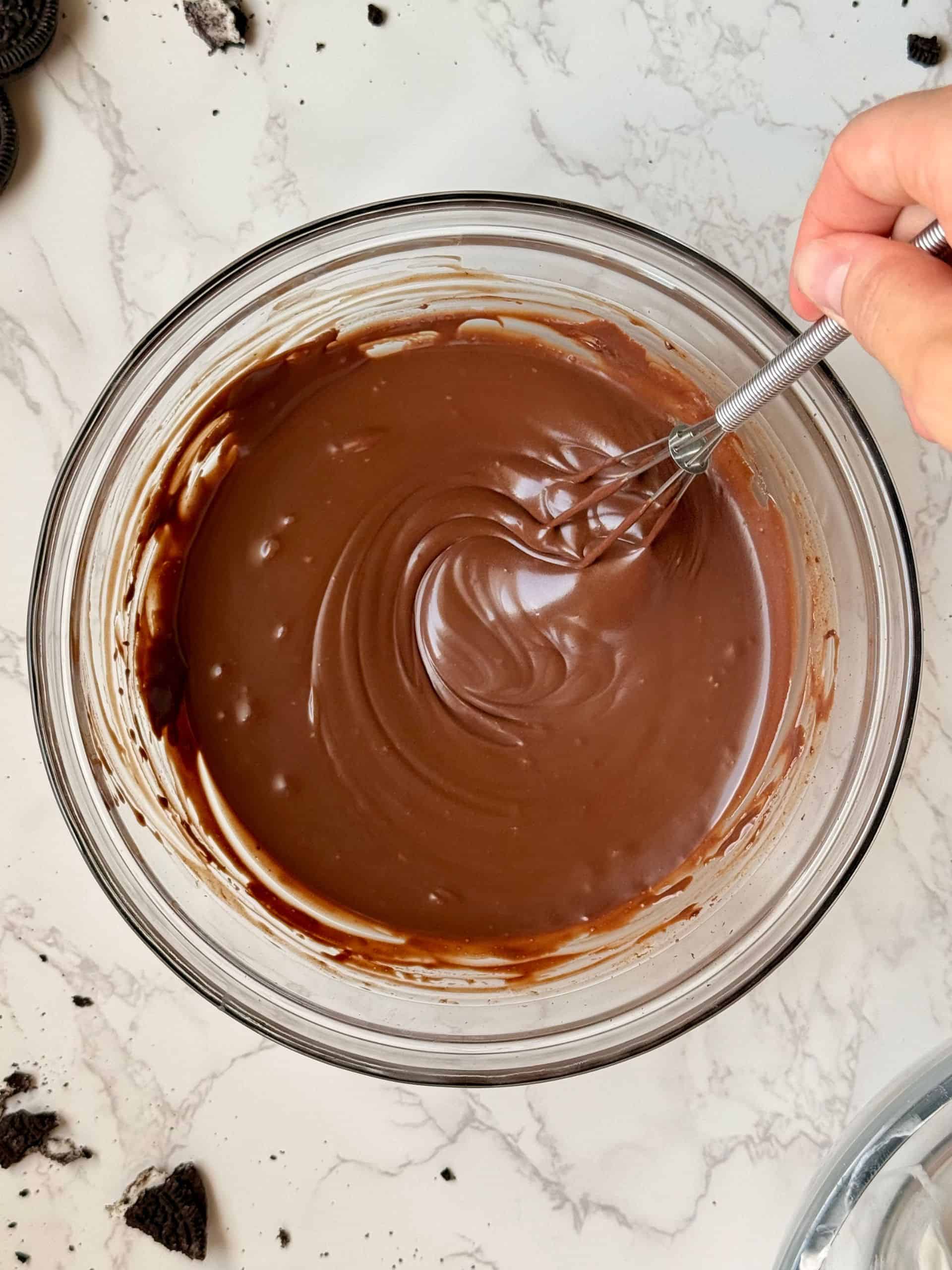 smooth and glossy chocolate ganache being stirred in bowl