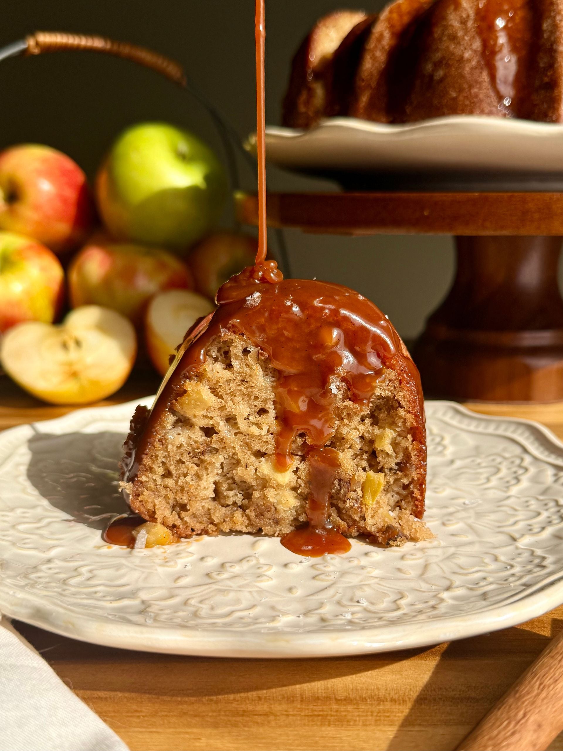 salted caramel apple bundt cake slice on plate with caramel drizzle over top